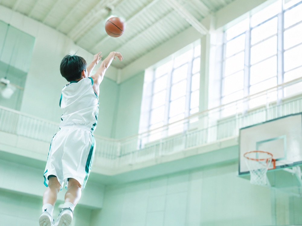 ジャンプシュートを打つ小学生バスケ選手